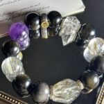 Black and gold crystal bracelet in motion, showing metallic luster and deep black hues in natural light