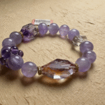 Close-up of natural amethyst bracelet with deep purple crystals, showing natural color zoning on velvet background