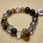 Amethyst bracelet displayed against a deep purple spiritual backdrop, evoking the fire element's passion and inner transformation.