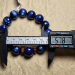 Raw kyanite, lapis lazuli and red agate specimens alongside finished bracelets, nature background
