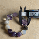 Green ghost crystal bracelet with garden-like inclusions, arranged with living plants