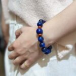 Lapis lazuli bracelet with deep blue stones and golden pyrite inclusions, royal blue background
