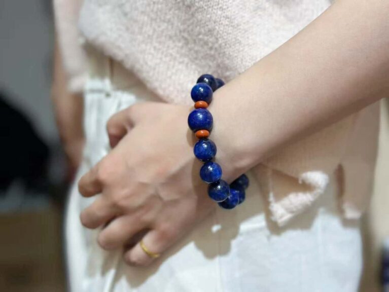 Lapis lazuli bracelet with deep blue stones and golden pyrite inclusions, royal blue background