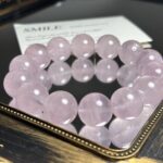 Close-up of rose quartz bracelet with natural pink crystals and delicate texture, soft focus on heart-shaped background