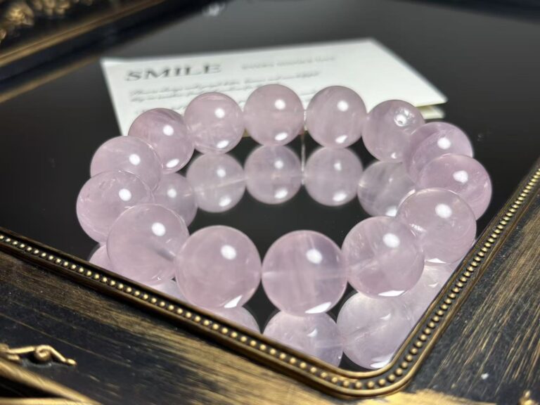 Close-up of rose quartz bracelet with natural pink crystals and delicate texture, soft focus on heart-shaped background