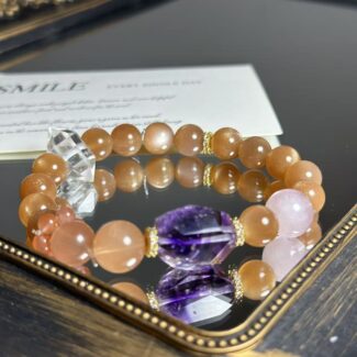Super seven crystal bracelet with purple hue and metallic flashes, displayed on mineral background