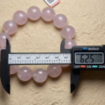 Rose quartz bracelet artfully arranged with fresh pink roses, creating a theme of love and tenderness