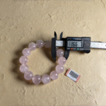 Macro shot of rose quartz beads showing natural inclusions and crystalline structures under studio lighting