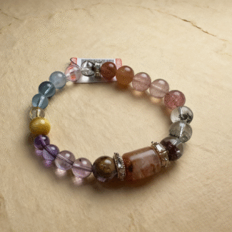 Water and wood element bracelets with aquamarine, green ghost crystal and wood fossil, displayed with fresh greenery